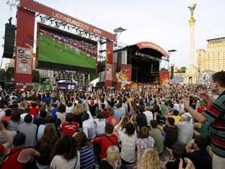 Euro 2012 fãs presta atenção ao jogo de Itália-Espanha no painel de LED da zona de fã em Kiev, Ucrânia